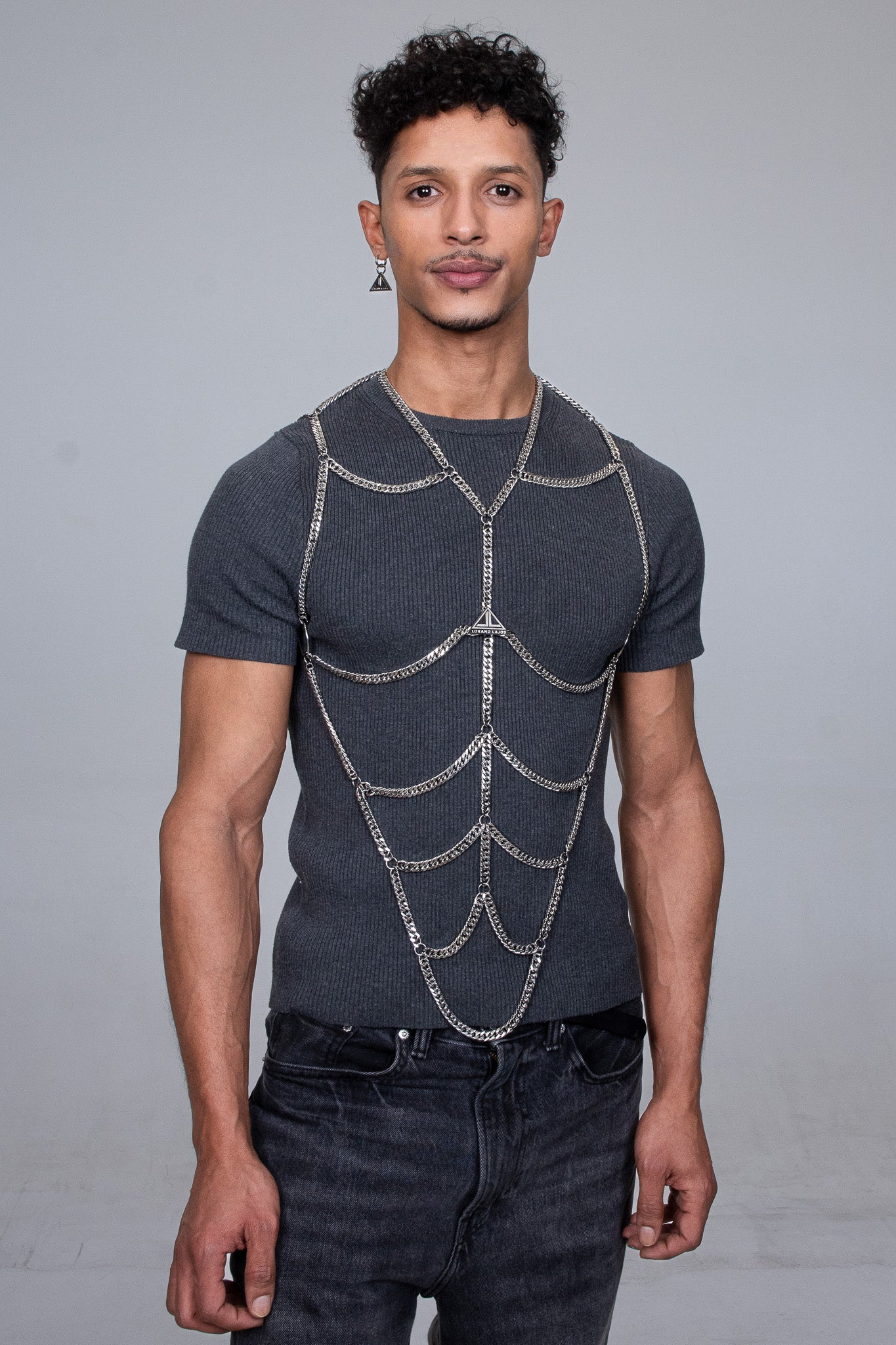 a handsome young men with strong arms is wearing the iconic body chain by the  modern fashion brand Lorand Lajos 