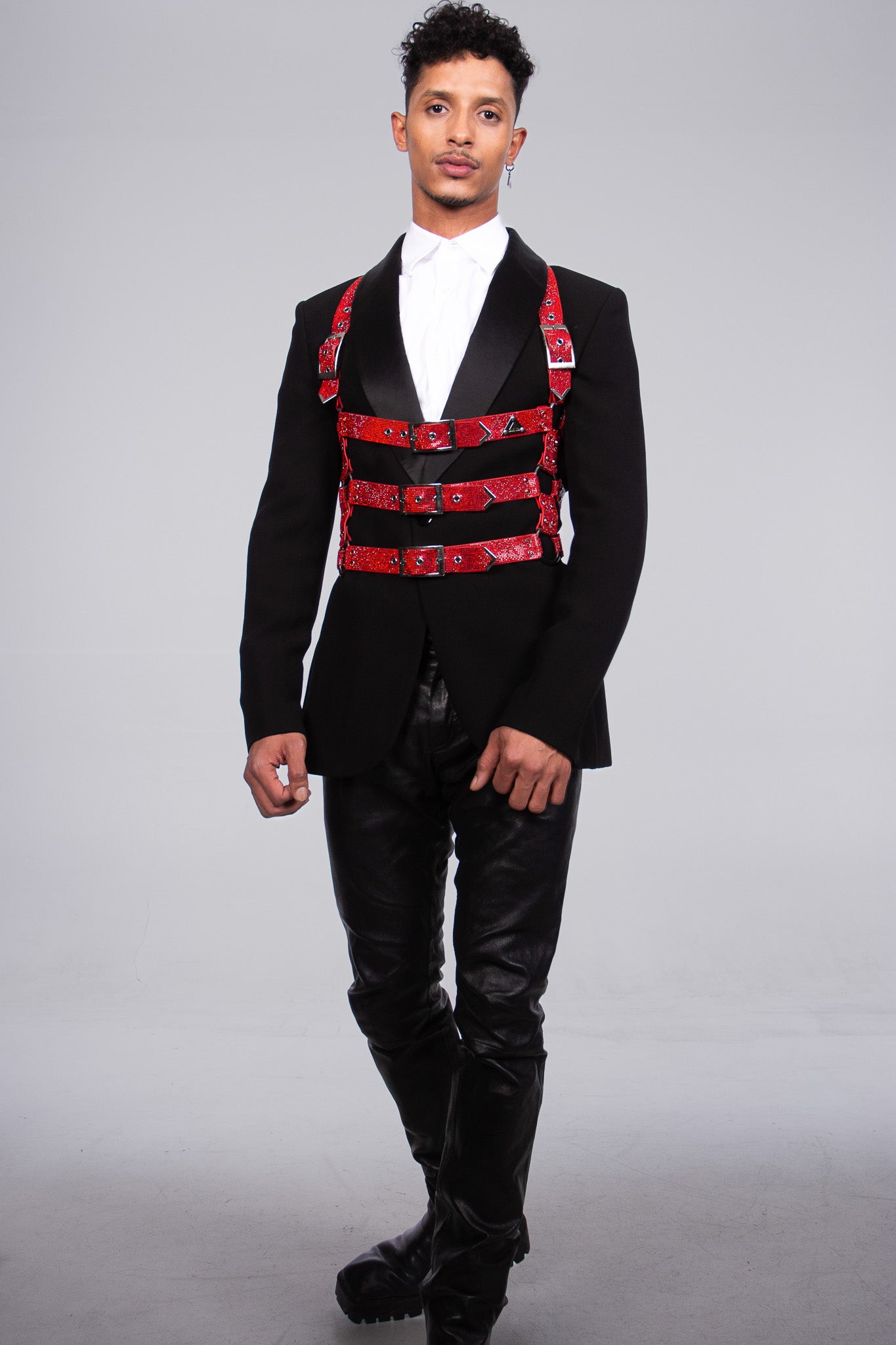 The picture shows a handsome male model posing for the accessory fashion brand Lorand Lajos. the shiny red crystals look very elegant against the black high quality fabric of the tuxedo.