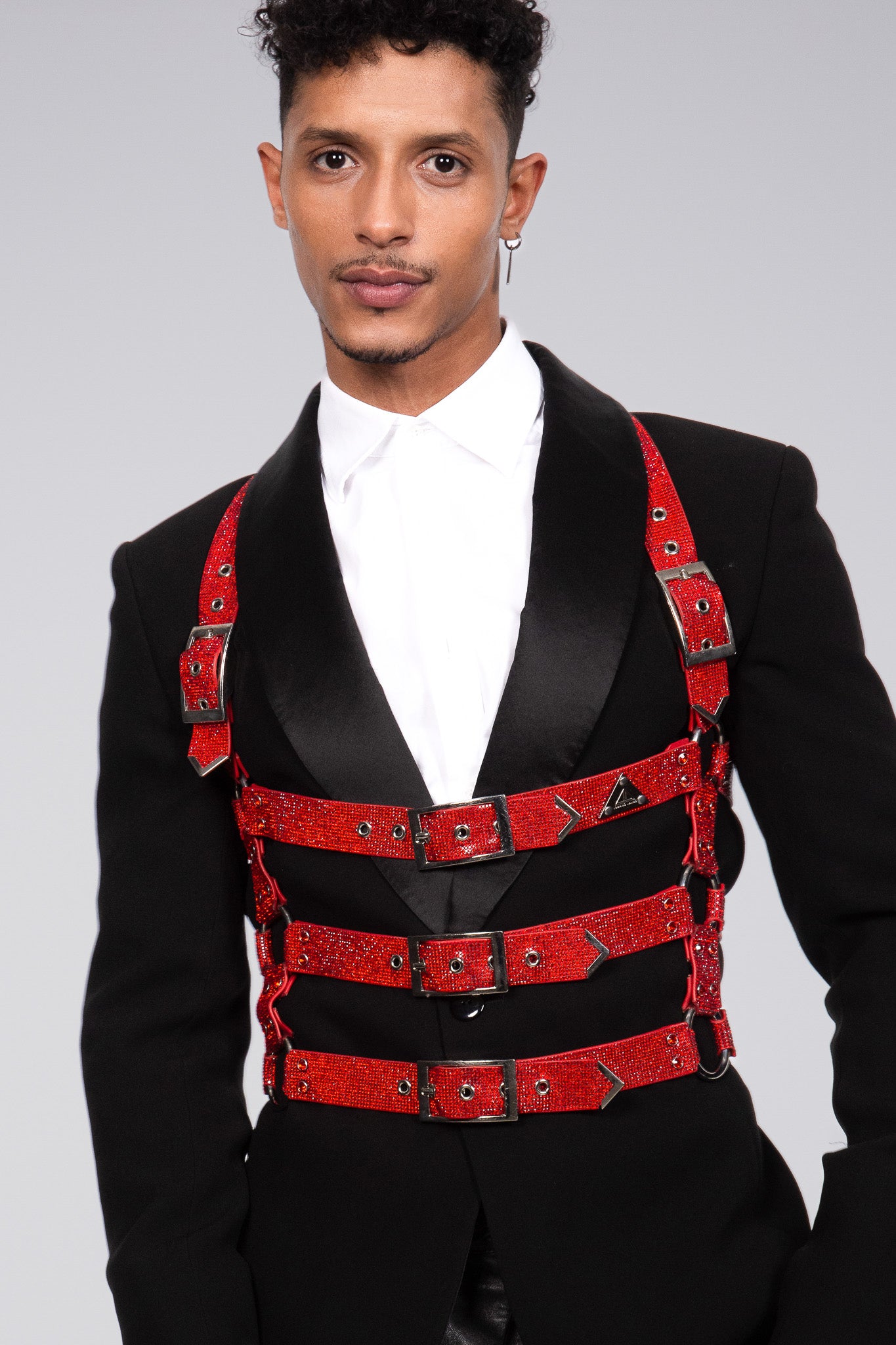 The cage harness in ruby red can be worn over a tuxedo to create an elegant and stylish look for men. The harness is eye catching because it sparkles and is made out of densely set crystals.