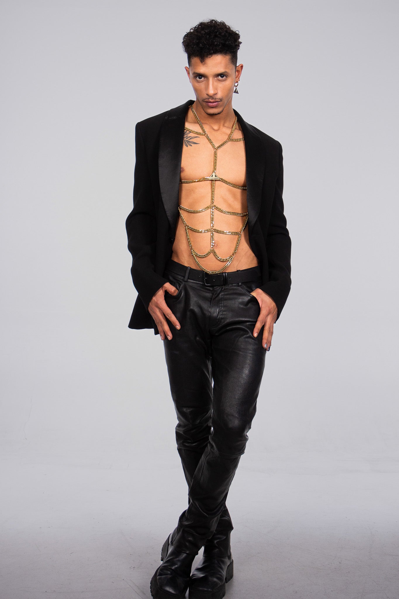 the product picture shows a muscular, gay young man wearing a sparkly golden body chain. his apps are highlighted by the accessory. He is also wearing an elegant dinner jacket. The Logo paquette shows Lorand Lajos