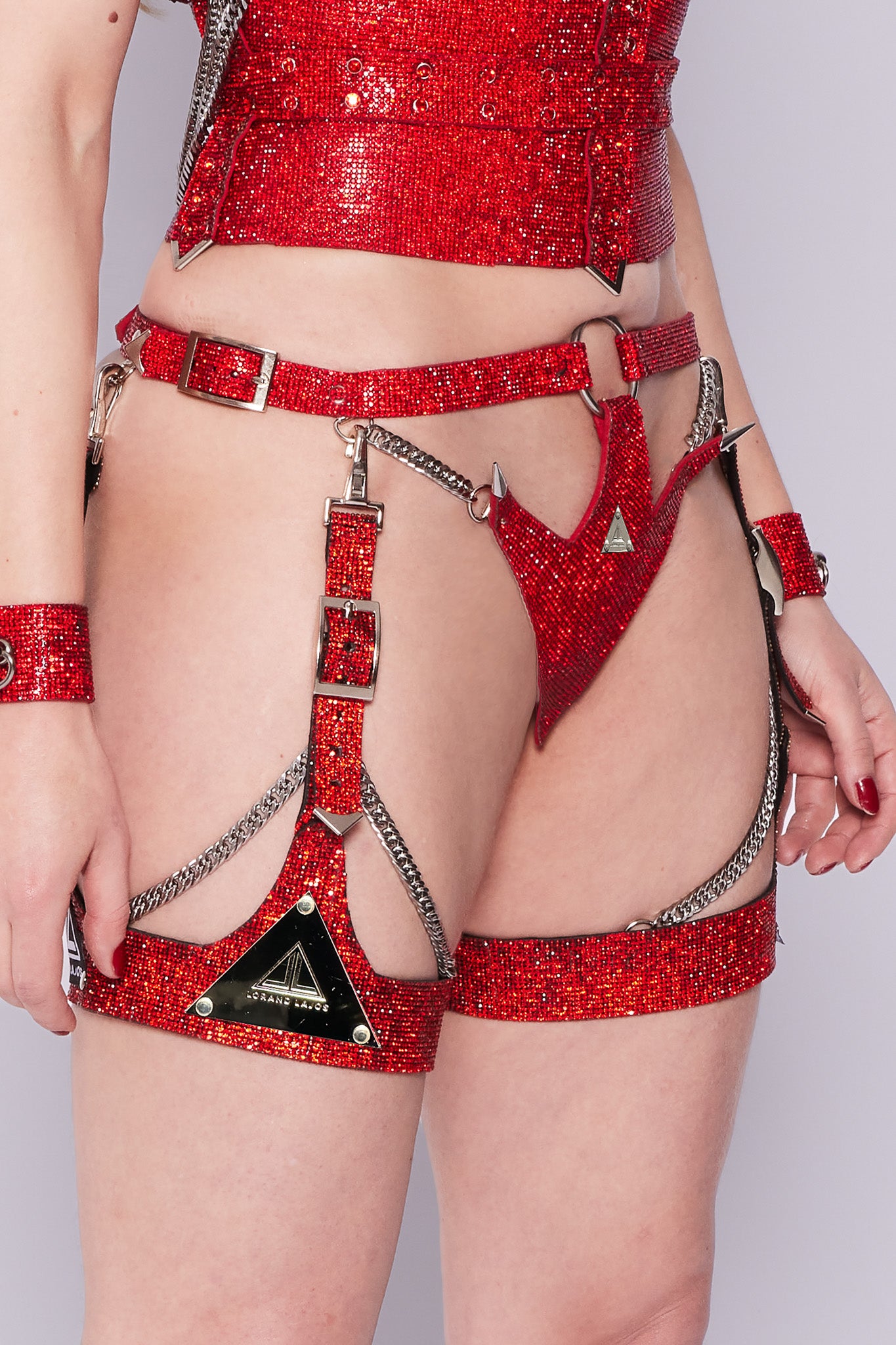 Chic red crystal garter adorned with a shimmering logo plaque for elegance