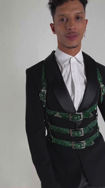 The video shows a hansom young man dancing in a very fashionable outfit by Lorand Lajos. The Harness has the shape of a rip cage and is shining in emerald green.
