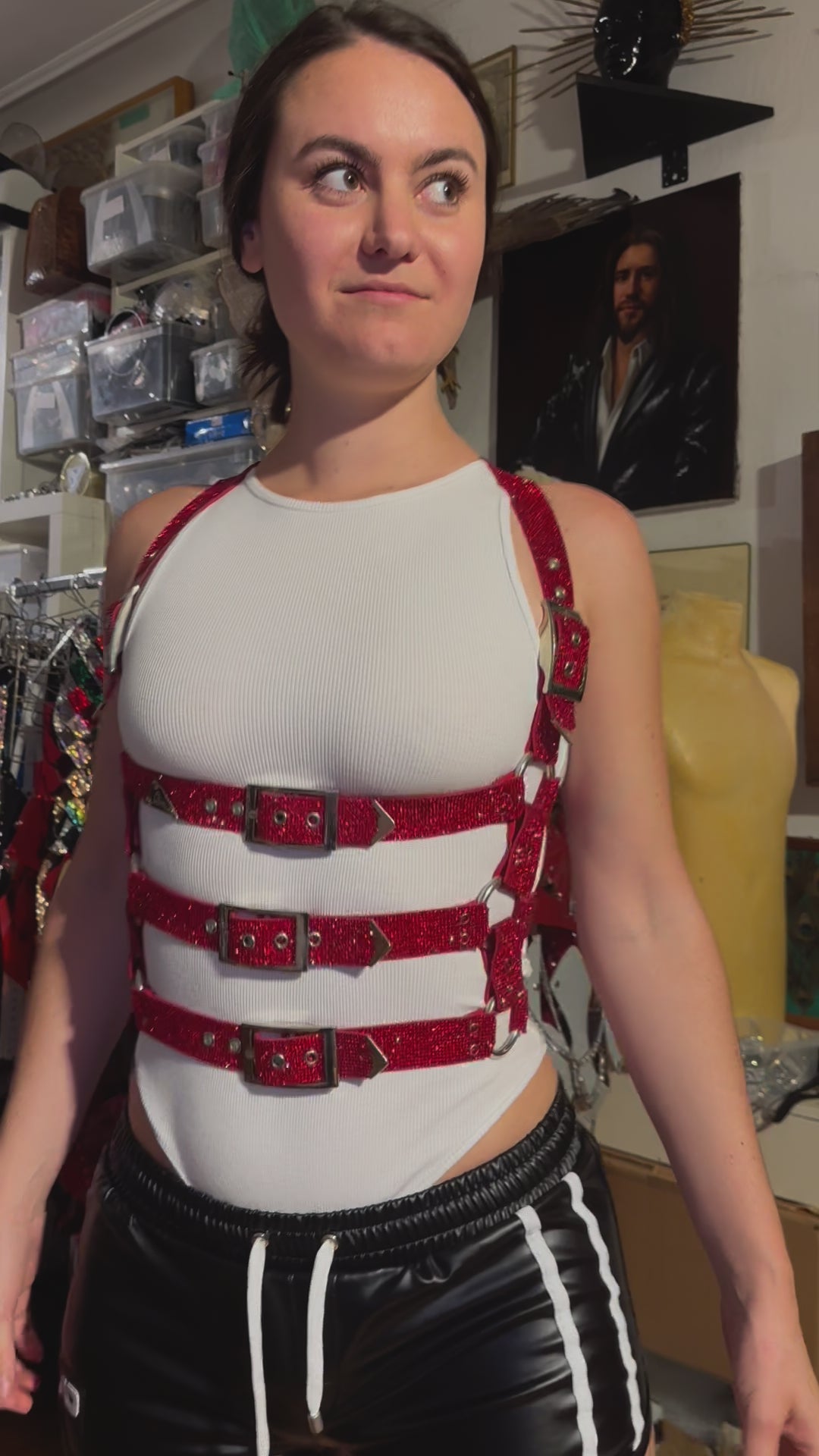 The video shows a beautiful women trying on the red sparkly cage harness at the atelier of the upcoming fashion brand Lorand Lajos